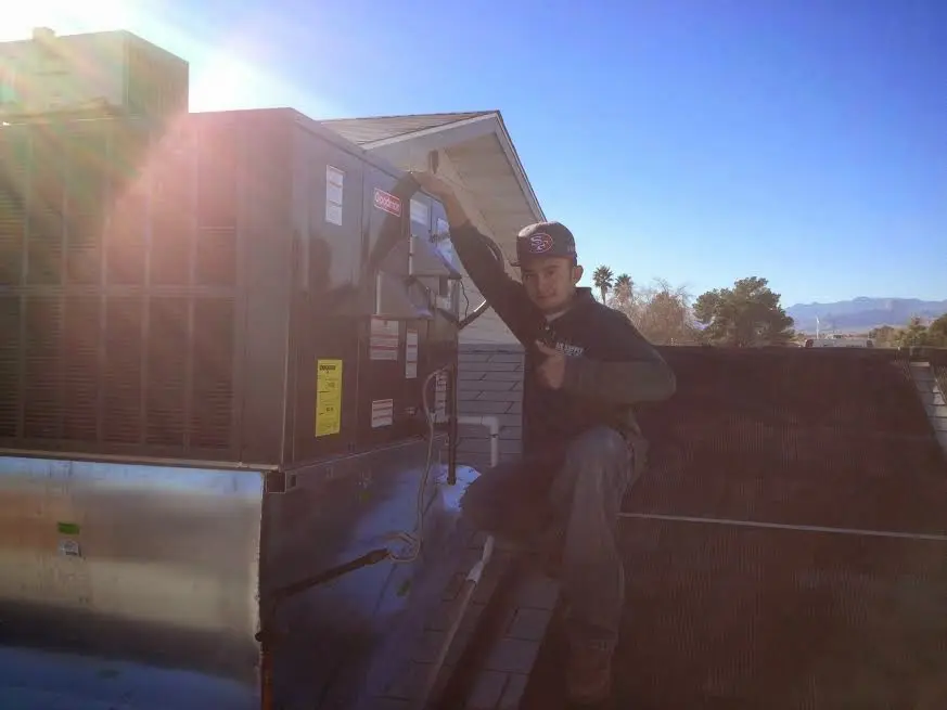 HVAC technician performing HVAC Inspection on a rooftop unit in Grandview